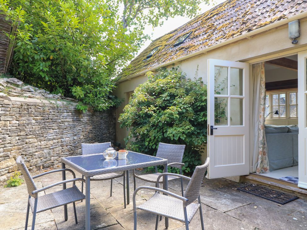 An outdoor area with a table and chairs at Upper Mill Barn, Coln St Aldwyns, near Bibury