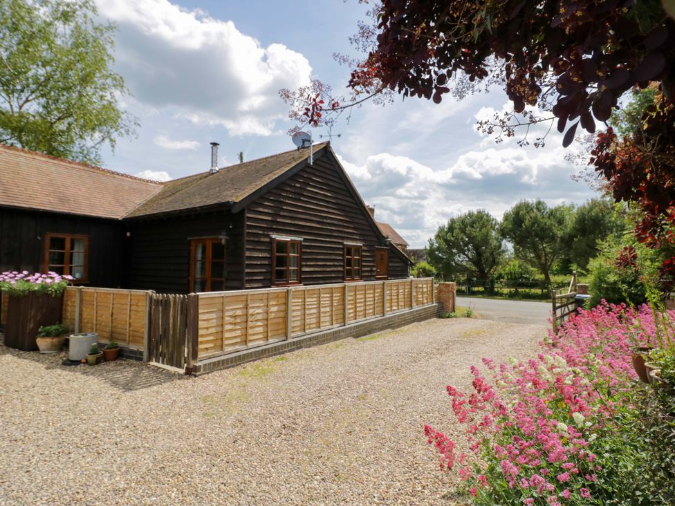 A house with a fence and flowers in the garden at Robbie's Barn, Fulready near Stratford-upon-Avon