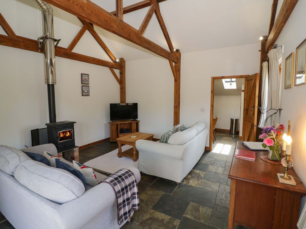 A living room with a sofa and television at Robbie's Barn Fulready near Stratford-upon-Avon