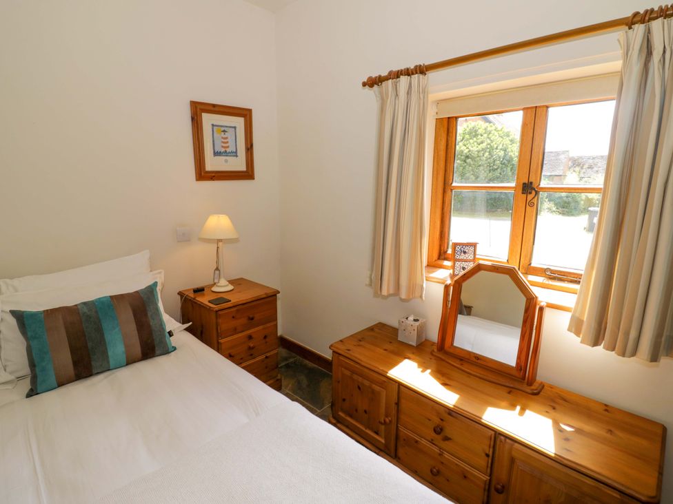 A bedroom with a bed and dresser at Robbie's Barn Fulready near Stratford-upon-Avon