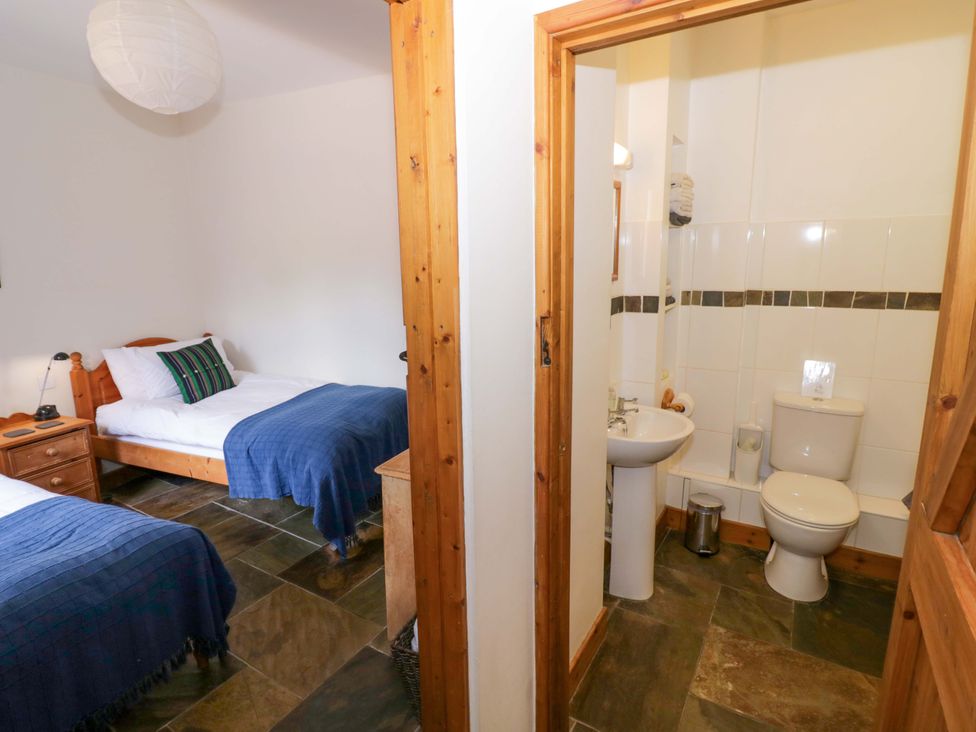 A bedroom with two beds and a bathroom at Robbie's Barn Fulready near Stratford-upon-Avon