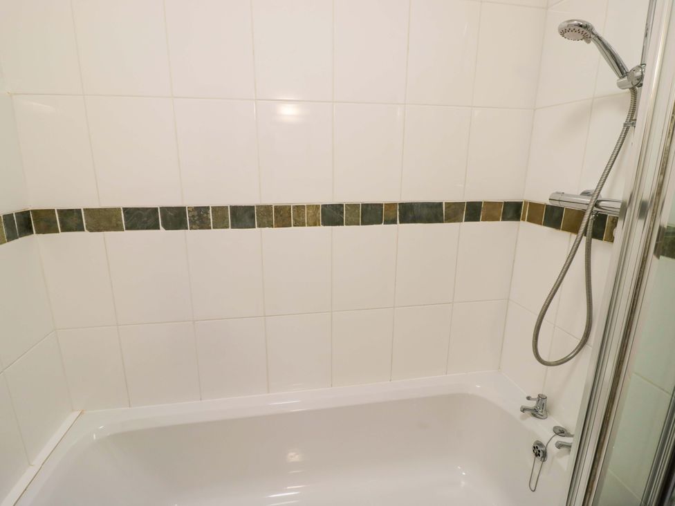 A bathroom with a bathtub and shower at Robbie's Barn Fulready near Stratford-upon-Avon