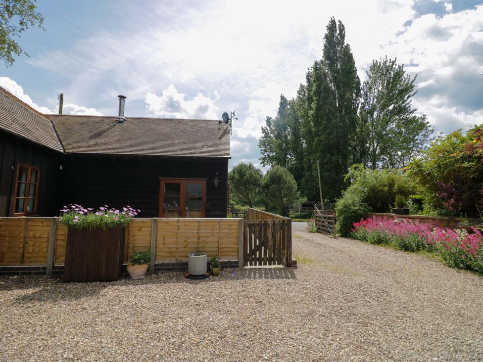 An outdoor area with a gravel path and flowers at Robbie's Barn Fulready near Stratford-upon-Avon