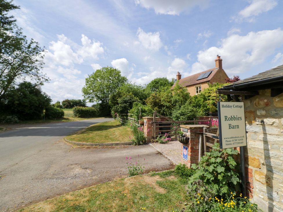 A cottage with a sign in front at Robbie's Barn Fulready near Stratford-upon-Avon