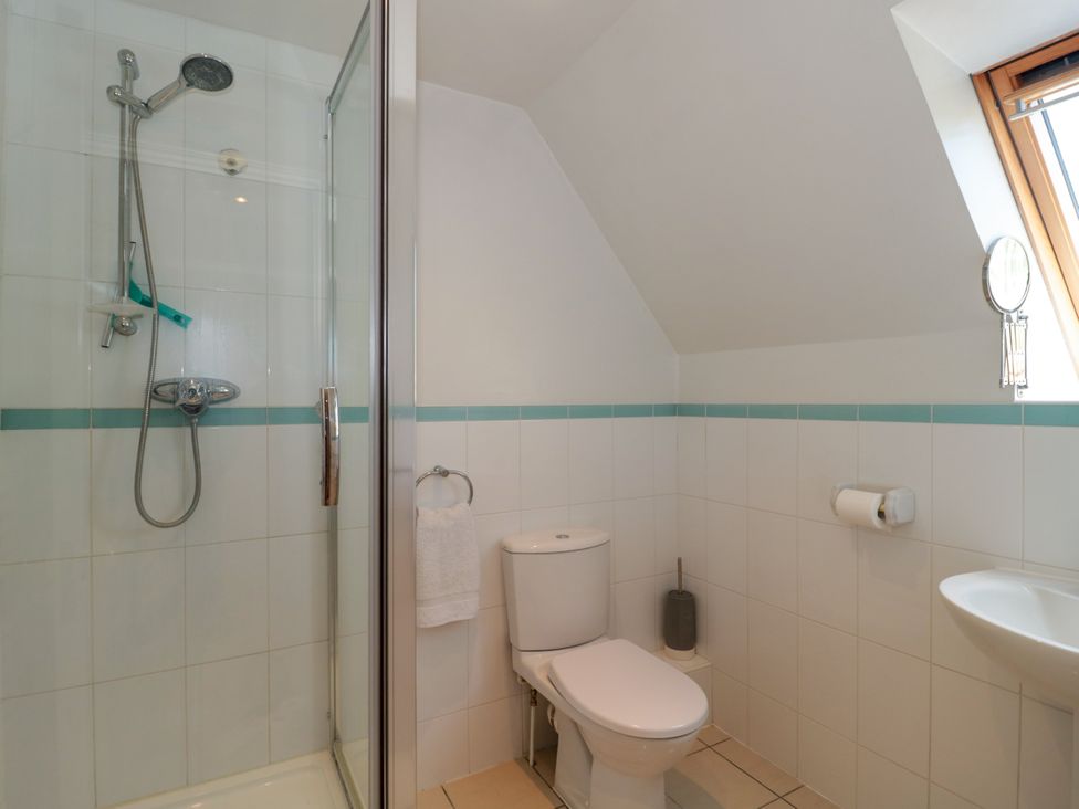 A bathroom with a shower stall toilet sink and window at Batemans in Nailsworth