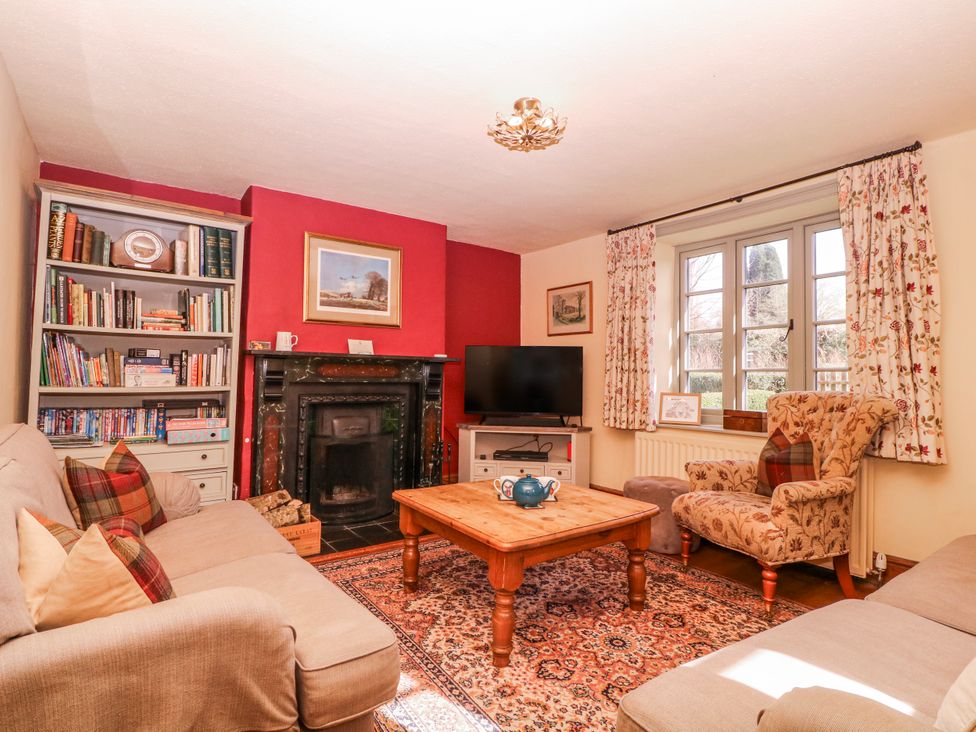 A living room with a bookshelf and fireplace at Elm View in Chipping Campden