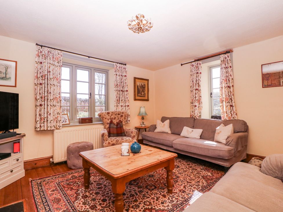 A living room with a sofa, coffee table, and television at Elm View in Chipping Campden