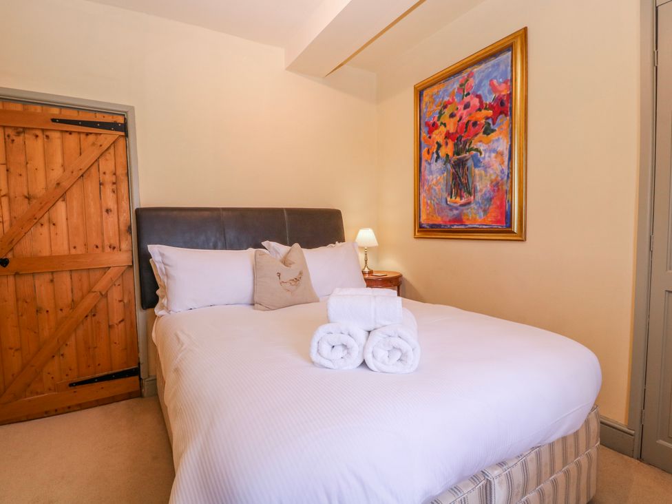 A bedroom with a bed and painting at Elm View in Chipping Campden