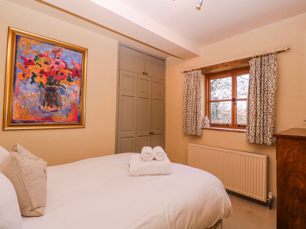 A bedroom with a bed and wardrobe at Elm View in Chipping Campden