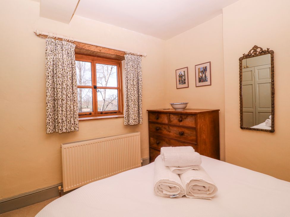 A bedroom with a window and a dresser at Elm View in Chipping Campden