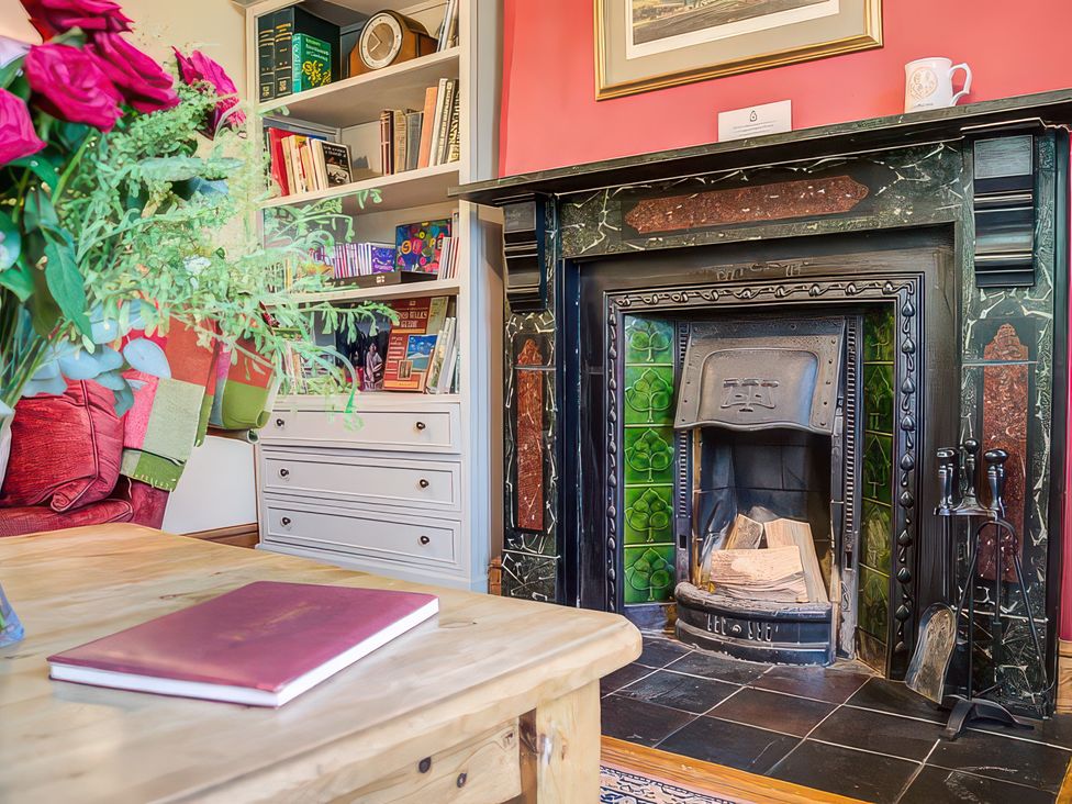 A living room with a fireplace and bookshelf at Elm View in Chipping Campden