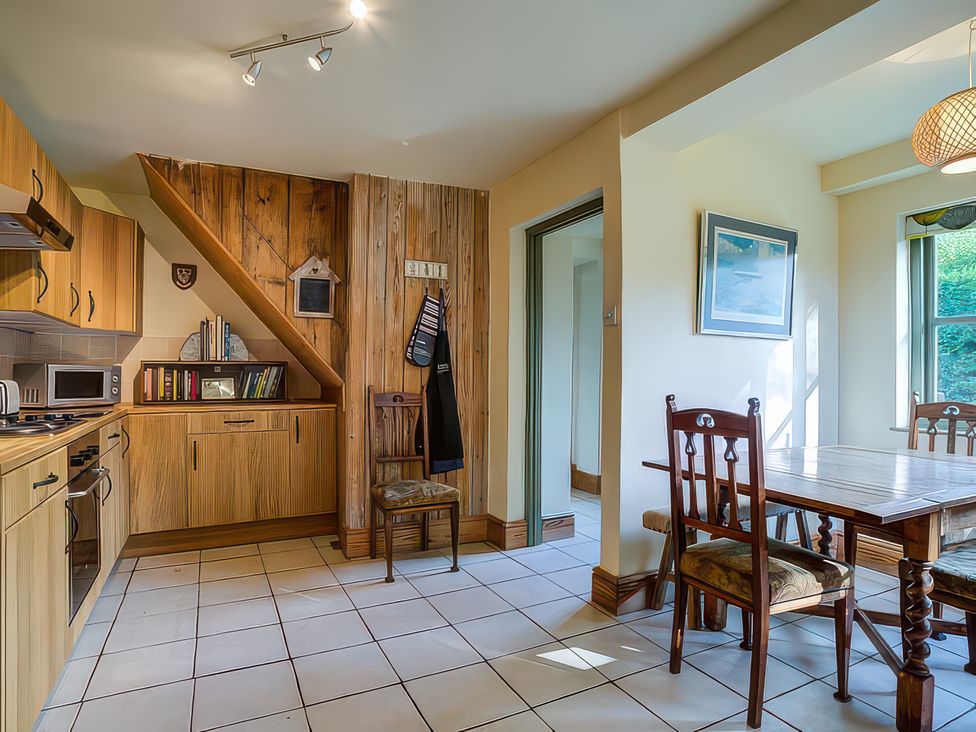 A kitchen with cabinets and dining area at Elm View in Chipping Campden