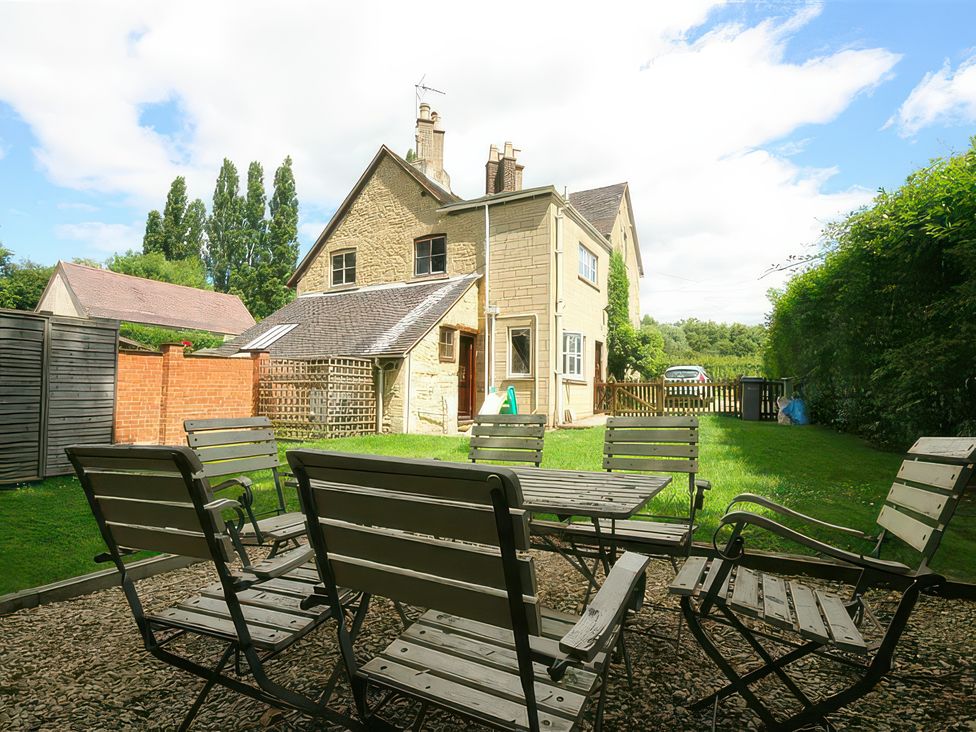 A garden with a table and chairs at Elm View Chipping Campden