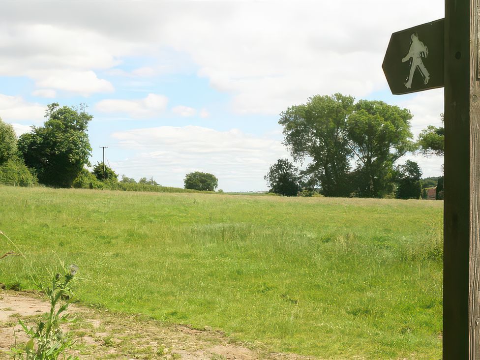 A field with trees and a signpost at Elm View Chipping Campden