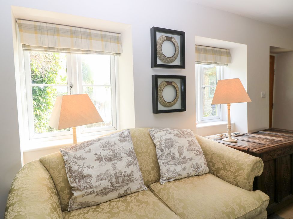 A living room with a sofa and lamps at Fairview Cottage in Milton-Under-Wychwood