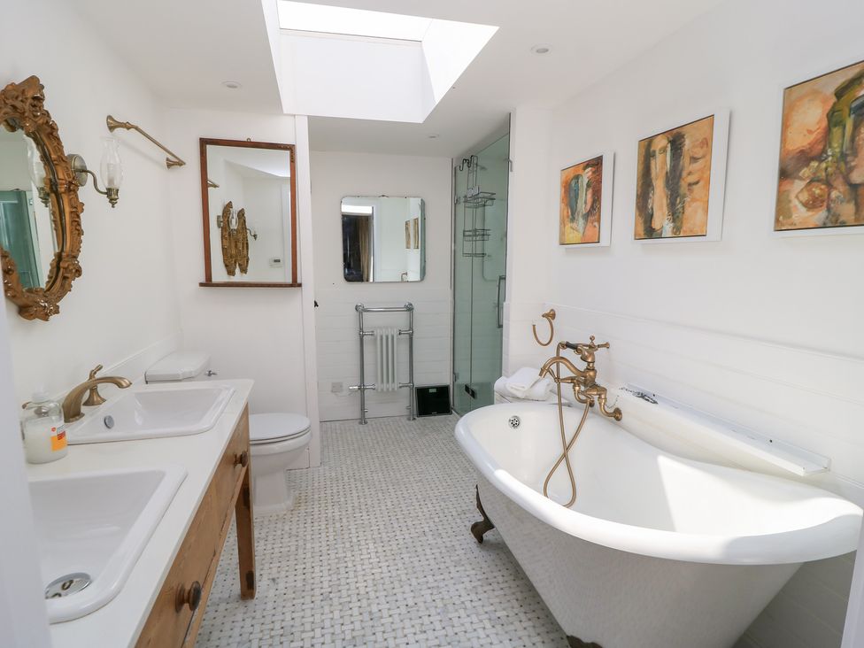A bathroom with a bathtub, sink, and shower at Fairview Cottage in Milton-Under-Wychwood