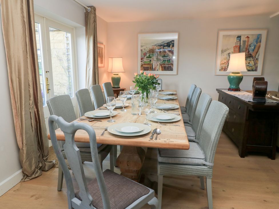 A dining room with a large table set for meals at Fairview Cottage in Milton-Under-Wychwood