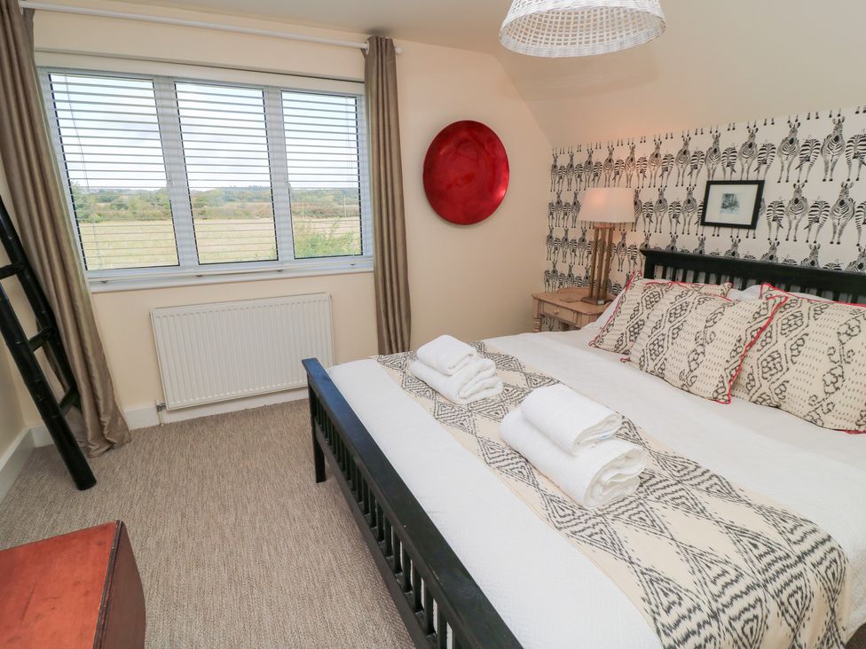A bedroom with a bed and window at Fairview Cottage in Milton-Under-Wychwood