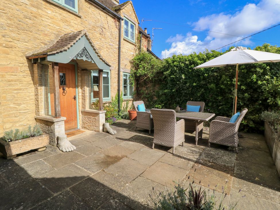A patio with a table and chairs at Fairview Cottage in Milton-Under-Wychwood