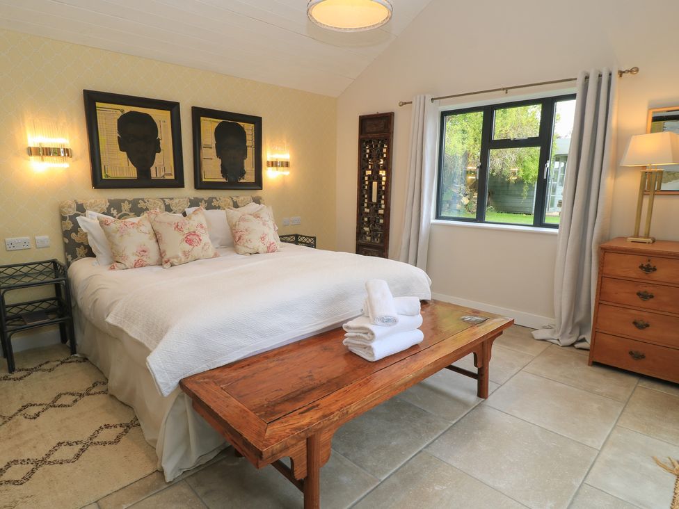 A bedroom with a bed and artwork at Fairview Cottage in Milton-Under-Wychwood