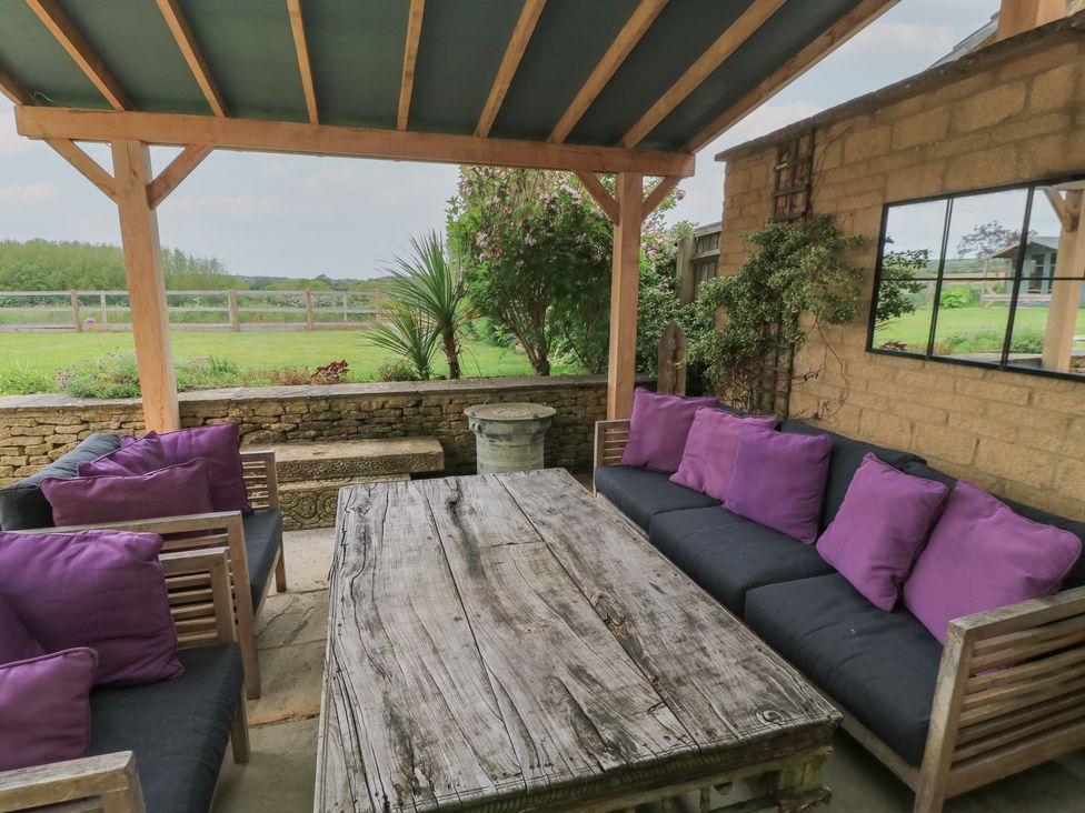 A garden sitting area with seating and table at Fairview Cottage in Milton-Under-Wychwood
