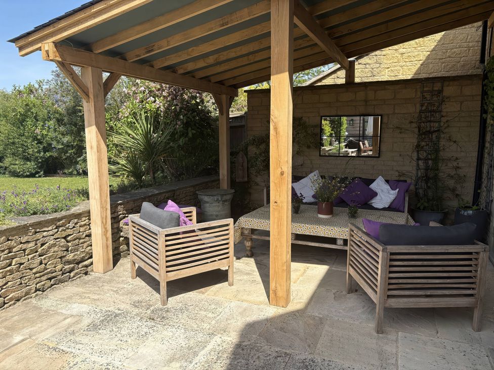 An outdoor patio with seating and a table at Fairview Cottage in Milton-Under-Wychwood