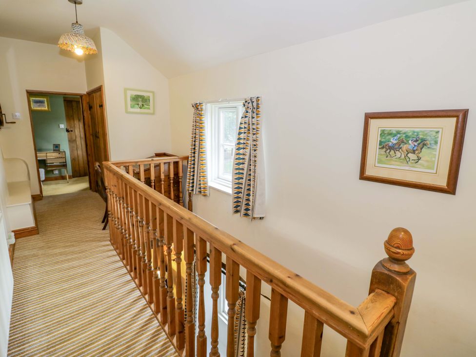 A hallway with a stair railing and a window at Elmhurst Cottage in Lower Quinton