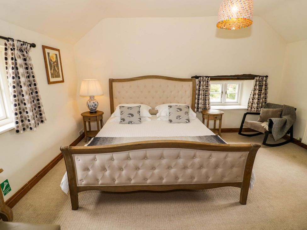 A bedroom with a bed and lamp at Elmhurst Cottage in Lower Quinton