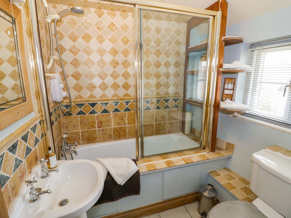 A bathroom with a bathtub, shower, sink, and toilet at Elmhurst Cottage Lower Quinton
