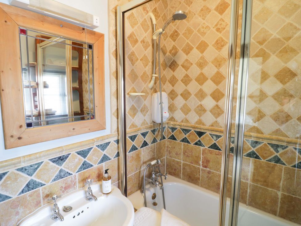 A bathroom featuring a bathtub and shower at Elmhurst Cottage in Lower Quinton