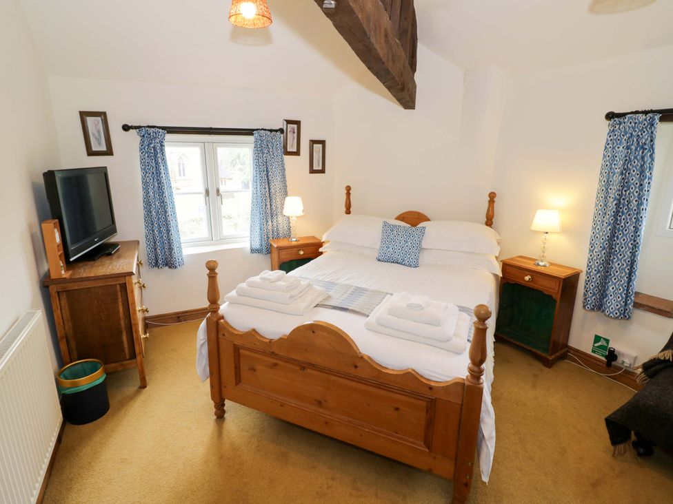 A bedroom with a bed and television at Elmhurst Cottage in Lower Quinton
