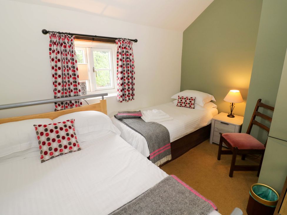 A bedroom with two beds and a window at Elmhurst Cottage in Lower Quinton