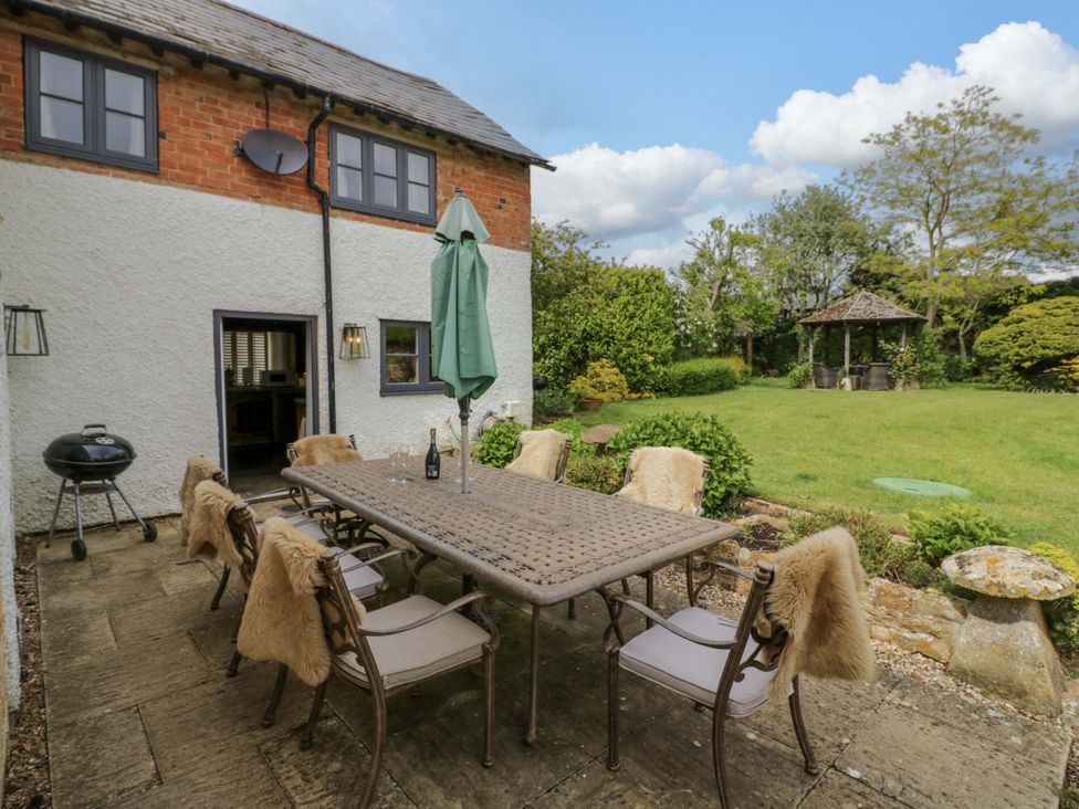 A patio area with a table and chairs at Elmhurst Cottage in Lower Quinton