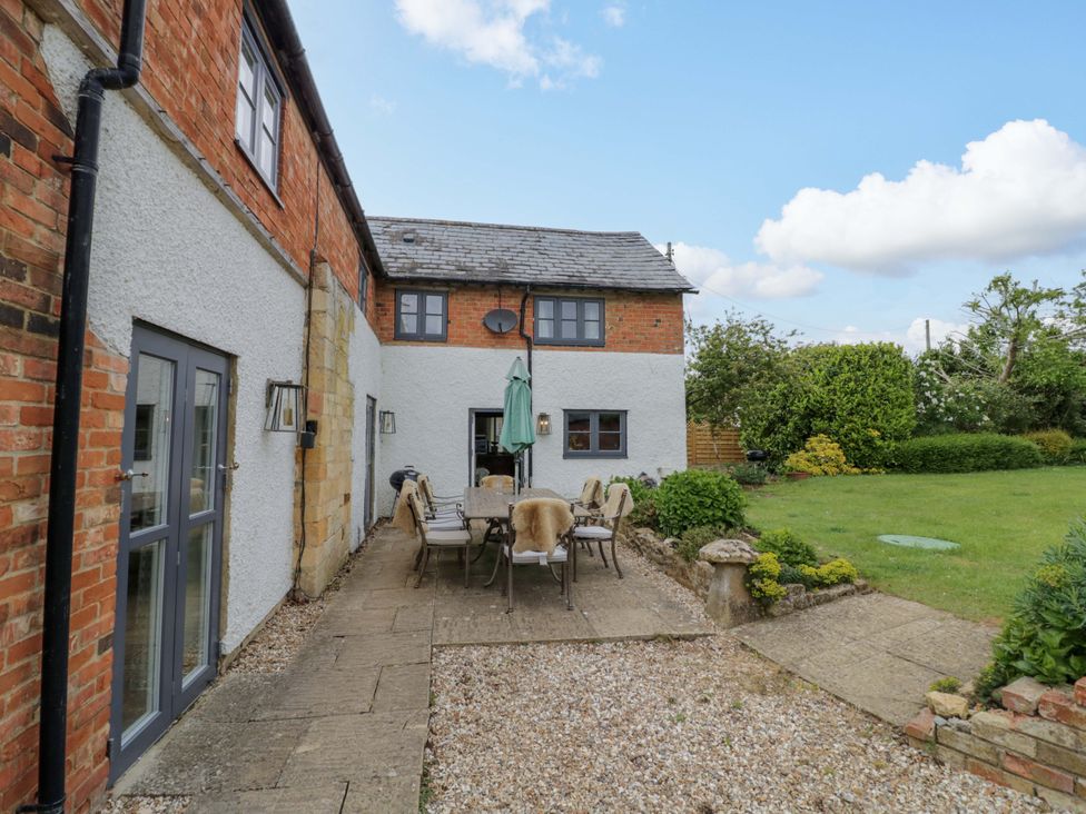 An outdoor area with a table and chairs at Elmhurst Cottage in Lower Quinton