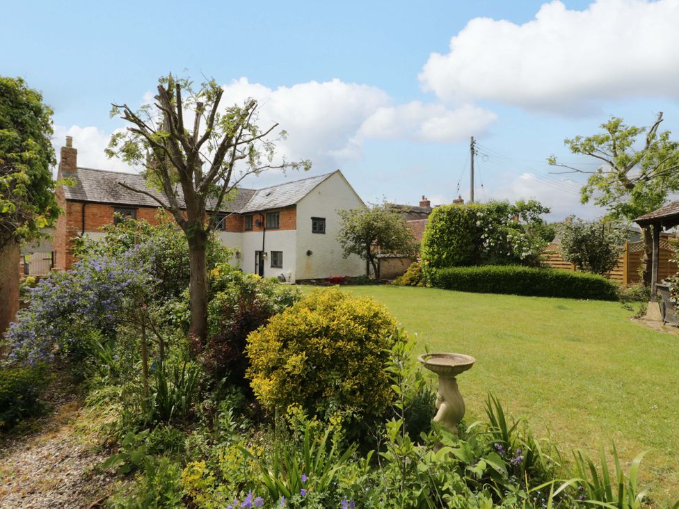 A house with a garden and trees at Elmhurst Cottage in Lower Quinton