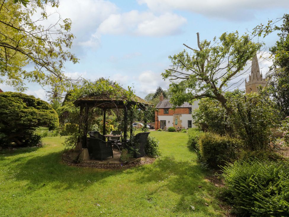 A garden with a gazebo and chairs at Elmhurst Cottage in Lower Quinton
