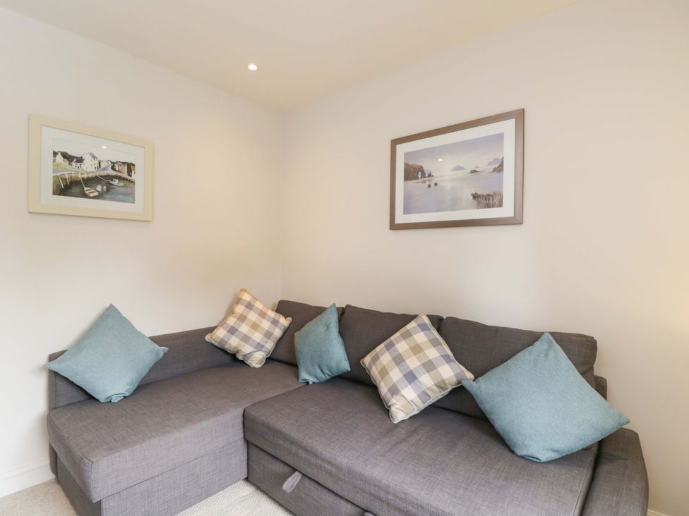 A snug with a sofa and artworks on the wall at Church View in Bourton-On-The-Water