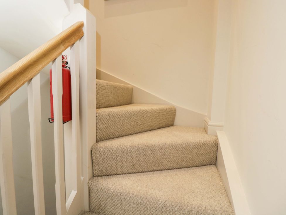 A staircase with a handrail and a fire extinguisher at Church View in Bourton-On-The-Water