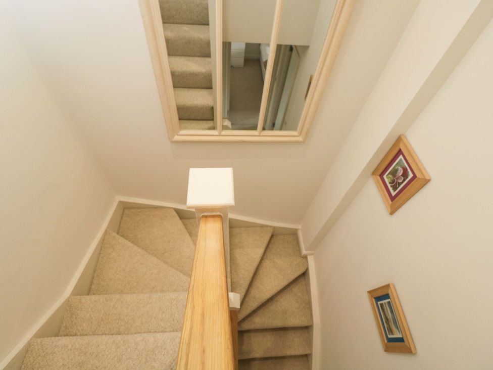 A staircase with a handrail and framed pictures at Church View in Bourton-On-The-Water