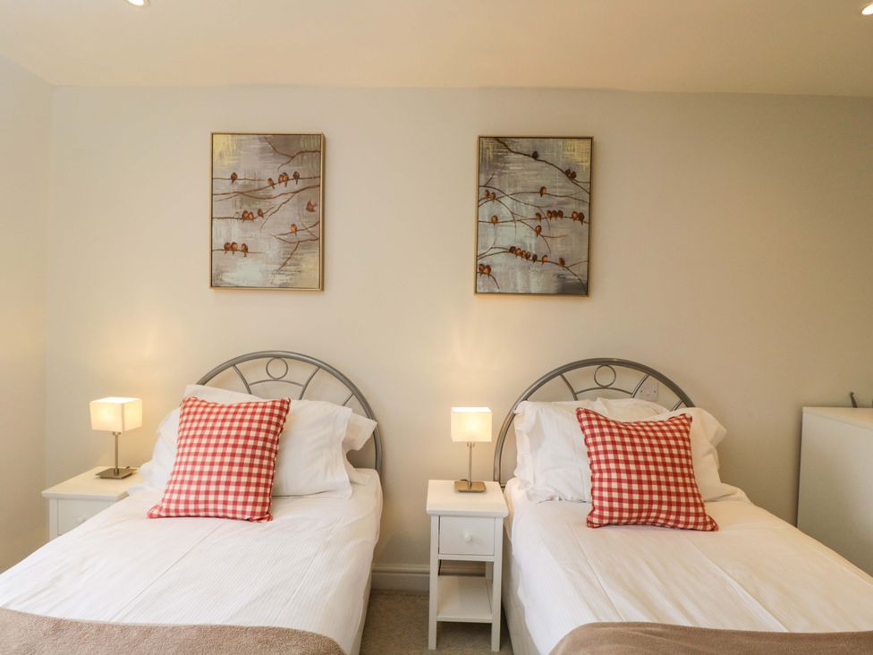 A bedroom with twin beds and artwork on the walls at Church View in Bourton-On-The-Water