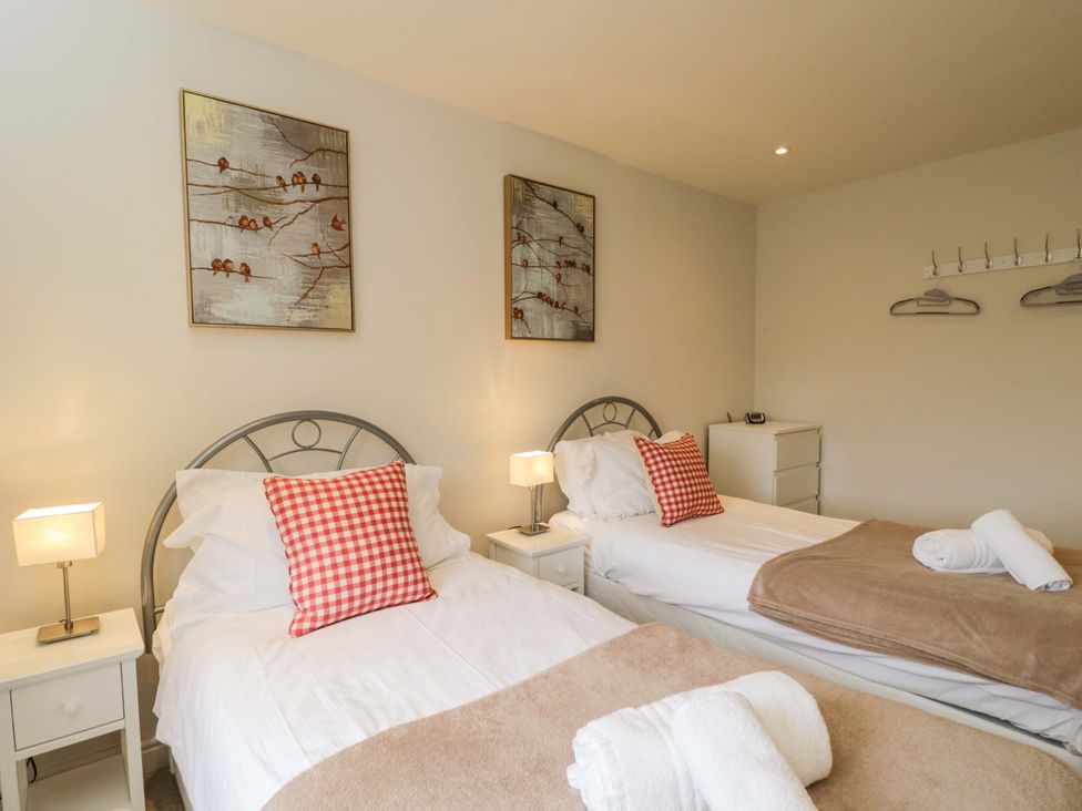 A bedroom with two beds and artwork on the walls at Church View in Bourton-On-The-Water