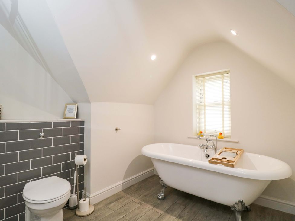 A bathroom with a bathtub and a toilet at Church View in Bourton-On-The-Water