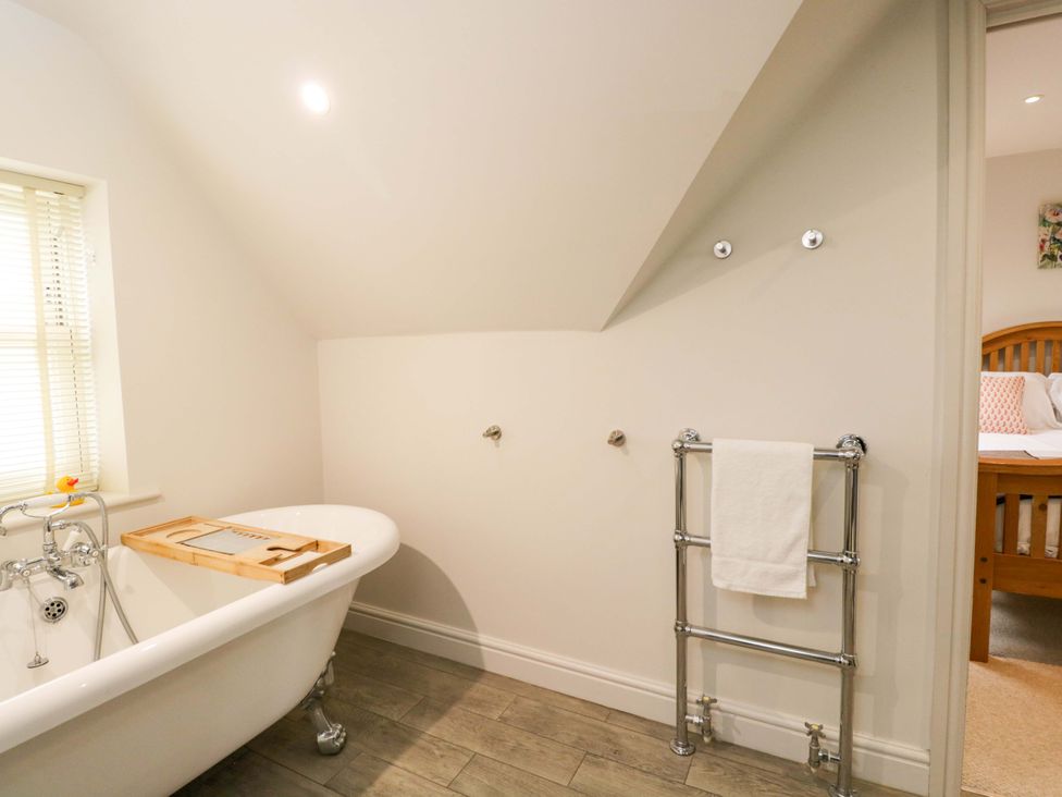 A bathroom with a bathtub and towel rail at Church View in Bourton-On-The-Water
