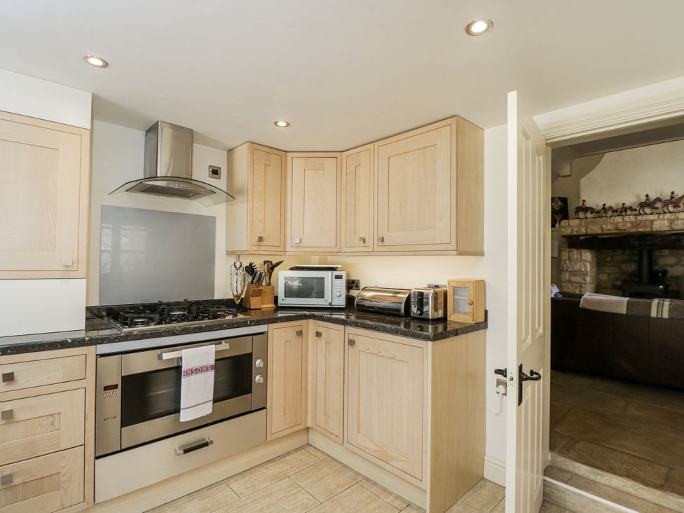 A kitchen with cabinets and appliances at The Old Reading Room in Bledington near Stow-on-the-Wold