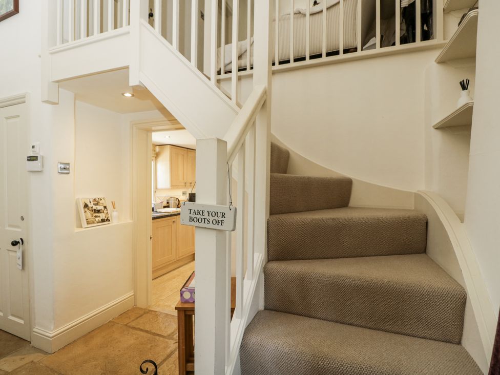 A staircase leading to a kitchen area at The Old Reading Room in Bledington near Stow-on-the-Wold