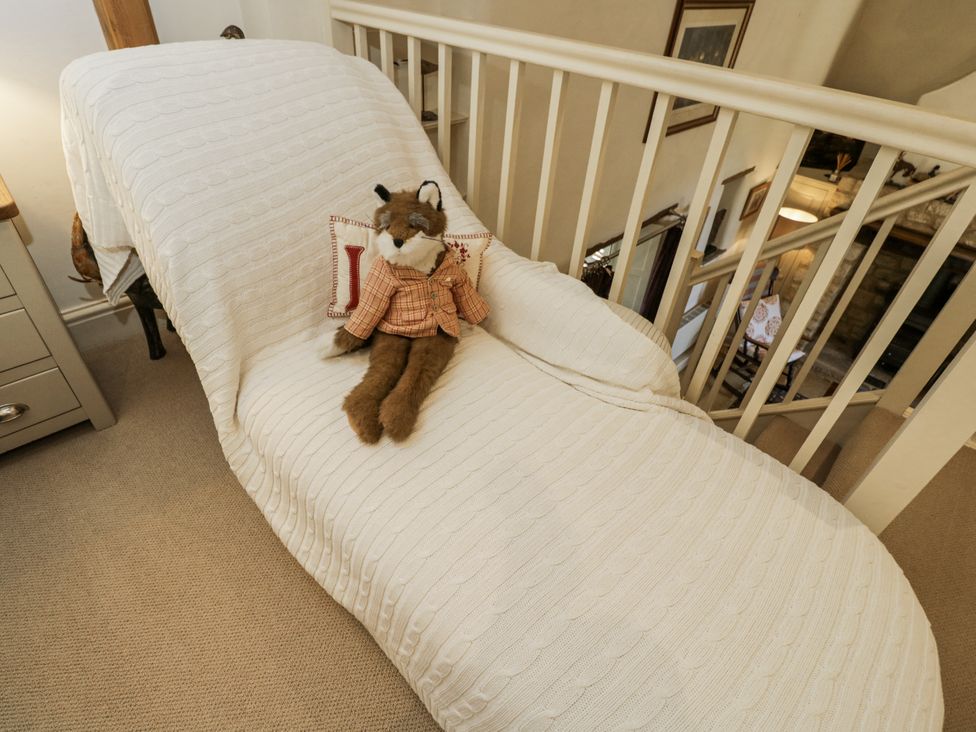 A chaise longue with a plush toy on it at The Old Reading Room Bledington near Stow-on-the-Wold