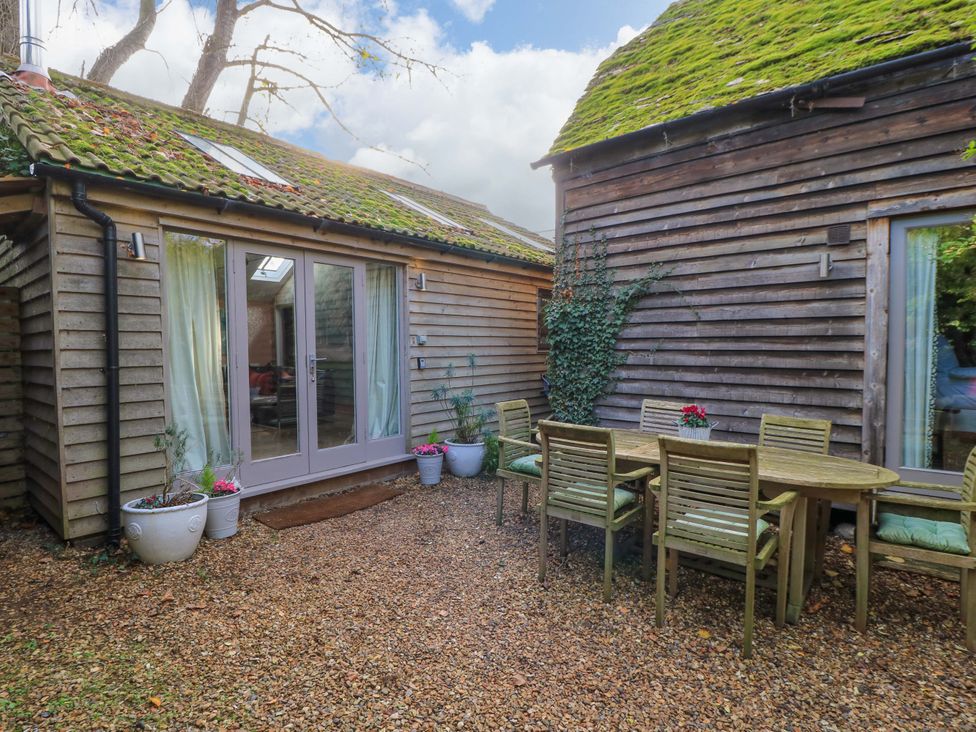 An outdoor area with chairs and a table at The Linhay in Little Coxwell near Faringdon