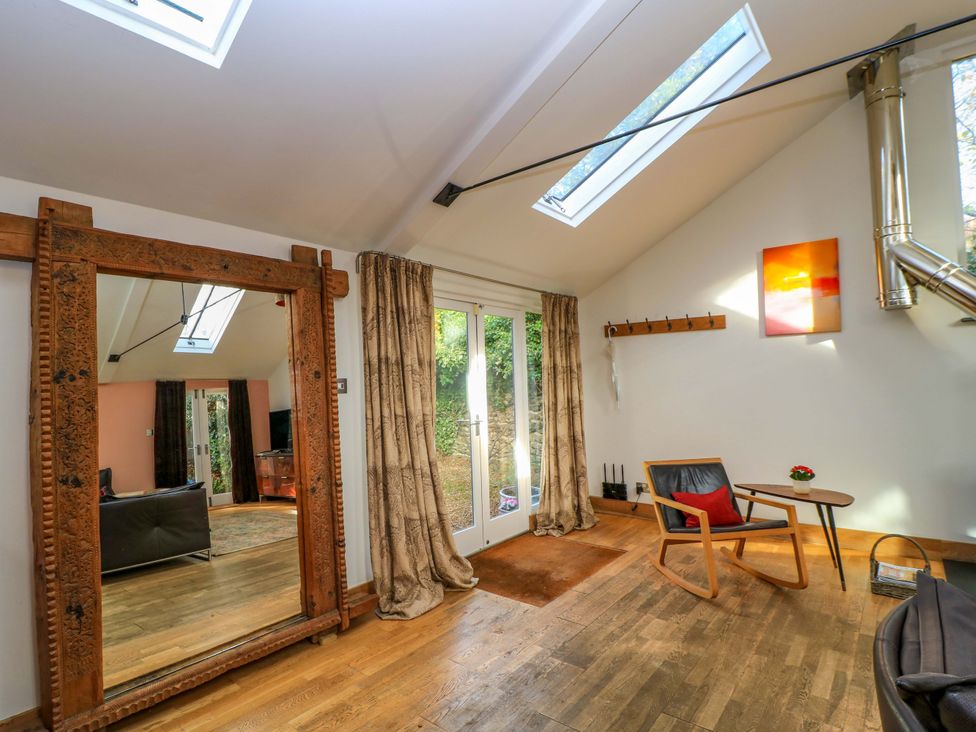 A living room featuring a mirror and sofa at The Linhay in Little Coxwell near Faringdon