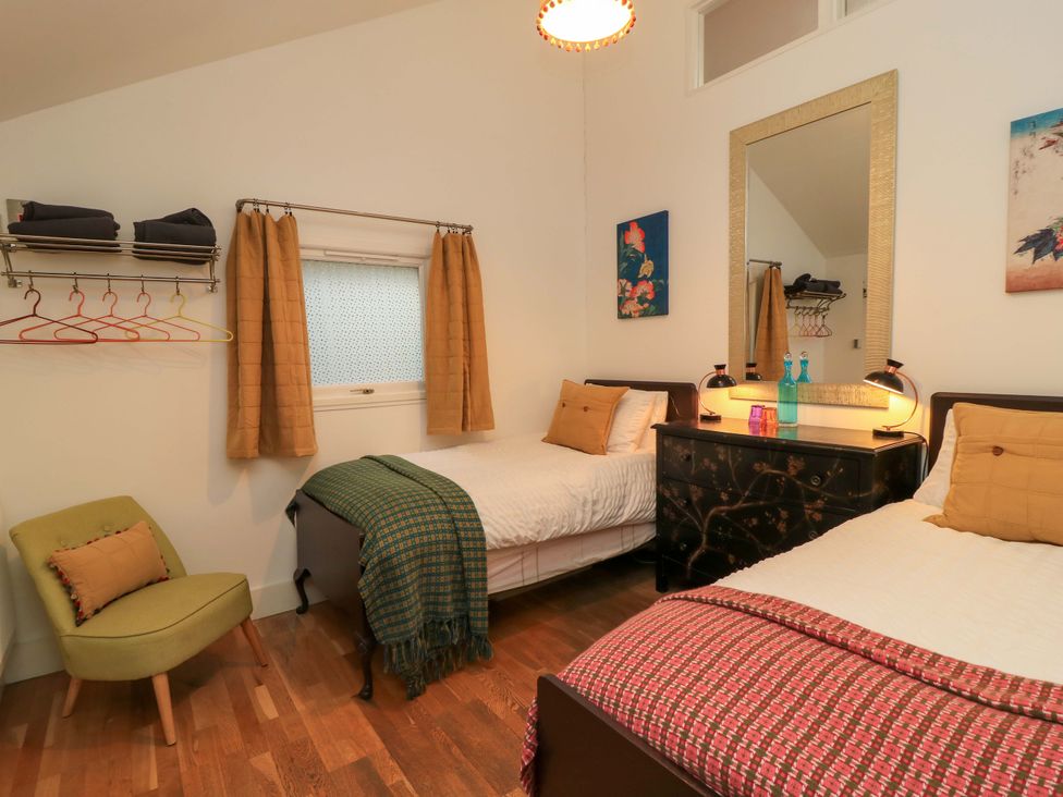 A bedroom with two beds and a mirror dresser at The Linhay in Little Coxwell near Faringdon