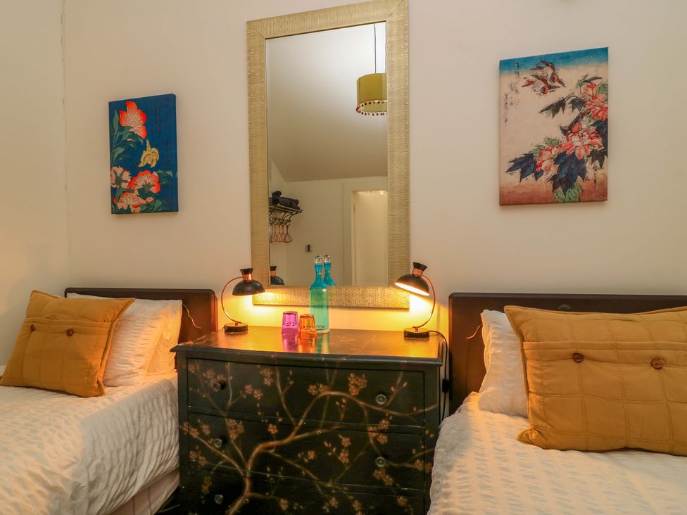 A bedroom with two beds and a mirror at The Linhay near Little Coxwell